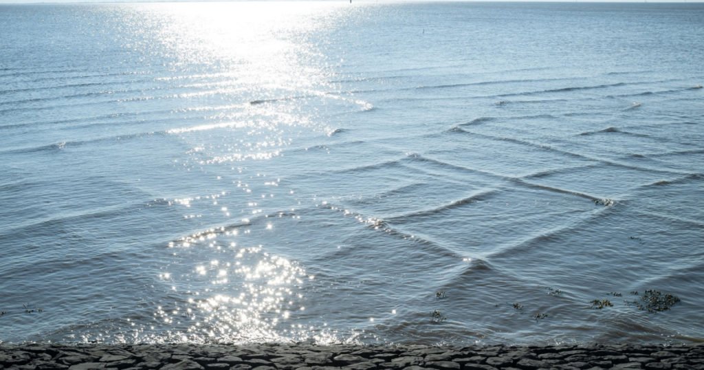 Sea with unusual square waves near the shore, against the blue sky. Beautiful spring landscape. 